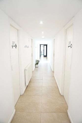 a corridor of an empty room with white walls and wooden floors at Dodo Suites in Mar del Plata
