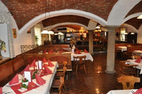 FrankingにあるKirchenwirt Mayrのテーブルと椅子と赤いナプキンを用意したレストラン