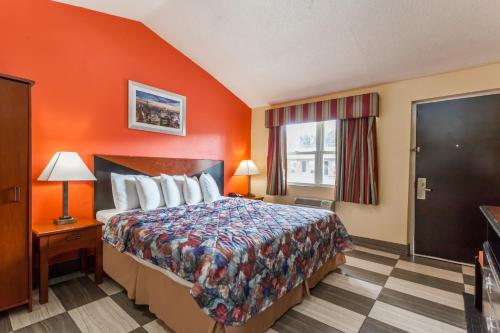 a hotel room with a bed and a window at Travelodge by Wyndham Jersey City in Jersey City