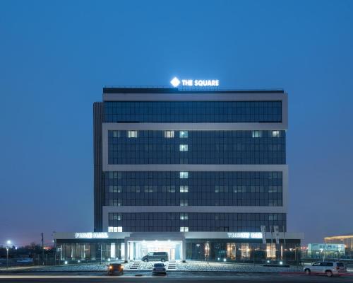 a tall building with a sign on top of it at The Square in Astana