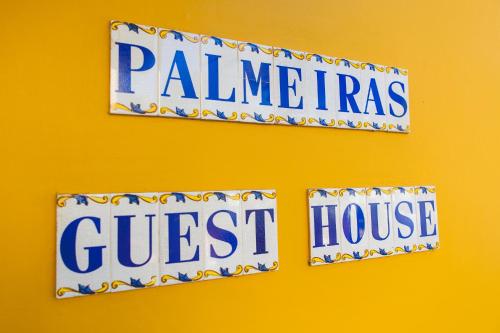 two signs on a wall with the words painineras and guest house at Palmeiras Guest House Maputo in Maputo