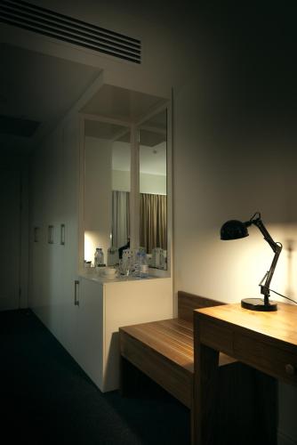 einen Schreibtisch mit einer Lampe auf einem Zimmer in der Unterkunft The Square in Astana
