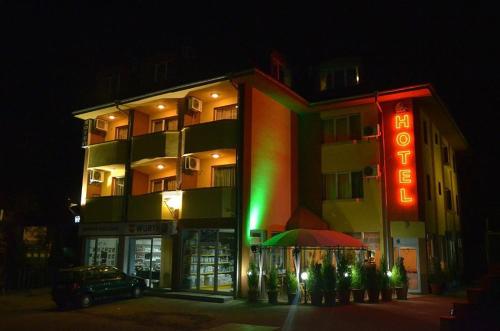 a hotel with a neon sign in front of it at Hotel Pilevski in Blagoevgrad
