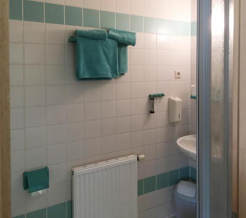uma casa de banho com lavatório, WC e toalhas em Hotel Lindenthal em Leipzig