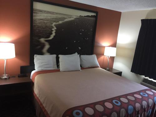 a hotel room with a large bed with two lamps at Super 8 by Wyndham College Station in College Station