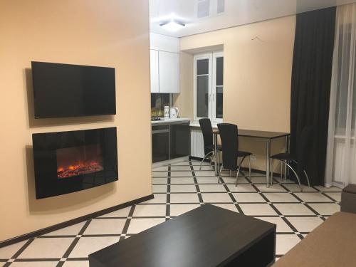 a living room with a fireplace and a table with chairs at Luxury Studios on Nauki Avenue in Kharkiv