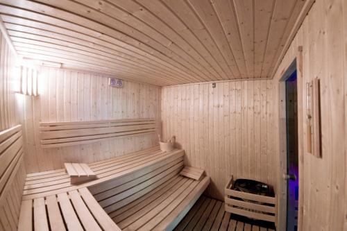 a wooden sauna with two wooden benches in it at Hotel Młyn Aqua Spa in Elblag