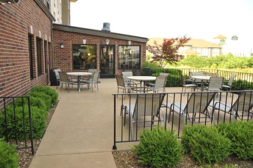 a patio with tables and chairs next to a brick building at Wingate by Wyndham Bowling Green in Bowling Green