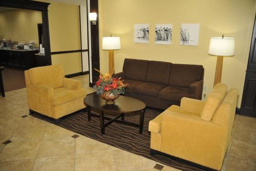 a living room with a couch and two chairs and a table at Wingate by Wyndham Bowling Green in Bowling Green