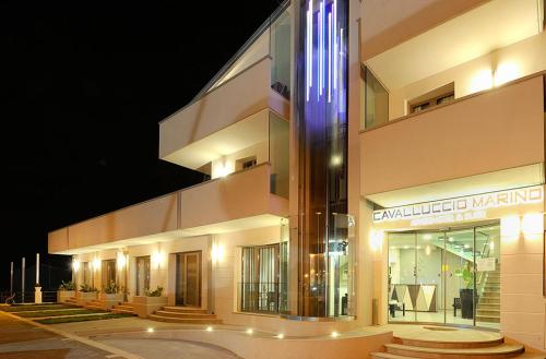 a large building with a lit up facade at night at Hotel & Residence Cavalluccio Marino in Rimini