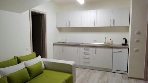 a living room with a green couch in a kitchen at Amso Residence in Sibiu