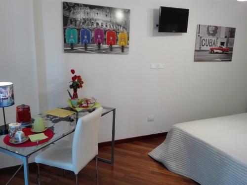a room with a table and a bed and a television at Residenza Piazza Moro in Bari