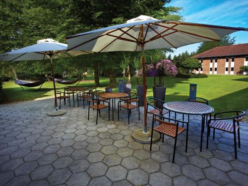 a group of tables and chairs under an umbrella at Frederik VI's Hotel in Odense