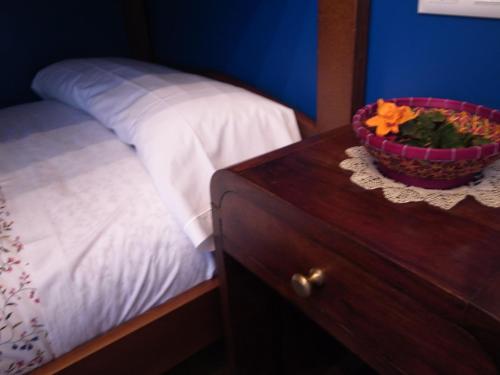 a bedroom with a bed and a bowl of flowers on a table at Apartamentos Rurales Les Martes in Felechosa