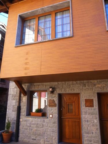 a house with a wooden door and windows at Apartamentos Rurales Les Martes in Felechosa
