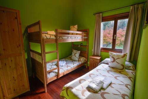 a green room with two bunk beds and a window at La Casina de Punticiella in El Pito