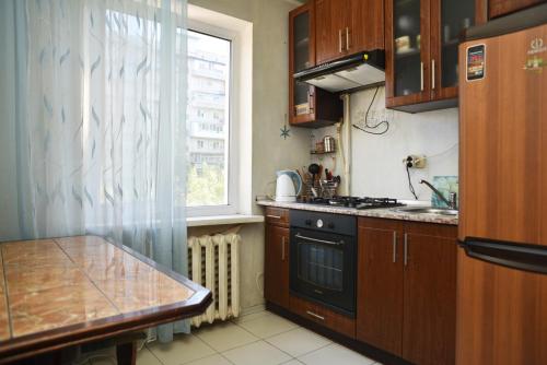 cocina con fogones, fregadero y ventana en Квартира по проспекту Героев Сталинграда, 13 (Оболонь), en Kiev