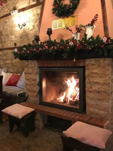 a fireplace in a living room with a fire at Varosi Guesthouse in Edessa