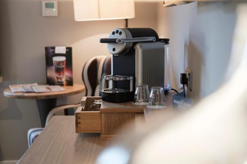 a coffee maker sitting on top of a table at The White Hart Hotel in Kingston upon Thames