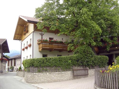 um edifício com varanda e uma árvore em frente em Kundlerhof em Stilves