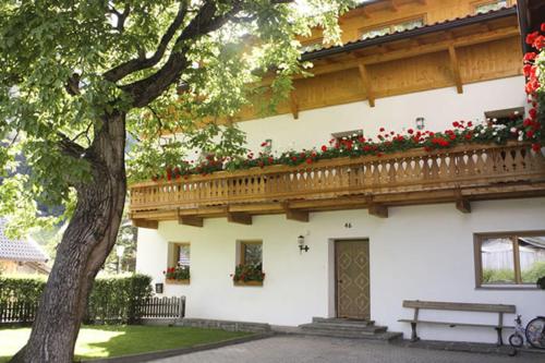 um edifício com uma varanda com flores vermelhas em Kundlerhof em Stilves