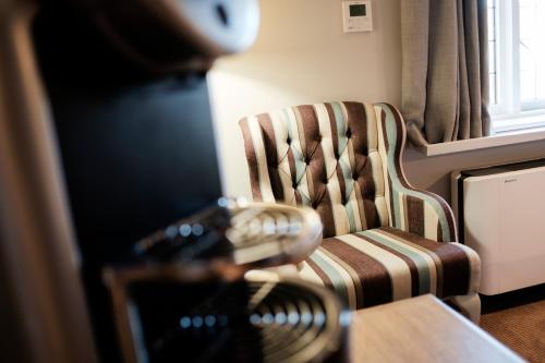 a kitchen with a stove and a chair and a window at The White Hart Hotel in Kingston upon Thames