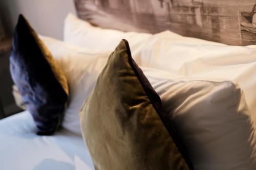 two pillows sitting on top of a bed at The White Hart Hotel in Kingston upon Thames