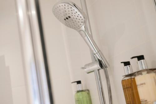 a shower head in a room with some bottles at The White Hart Hotel in Kingston upon Thames