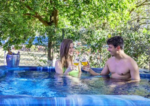 Un uomo e una donna seduti in piscina di Brotas Eco Hotel Fazenda a Brotas