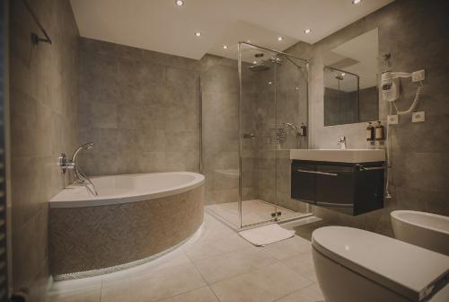 een badkamer met een bad, een wastafel en een toilet bij Hotel Restaurant Boss in Miłosław