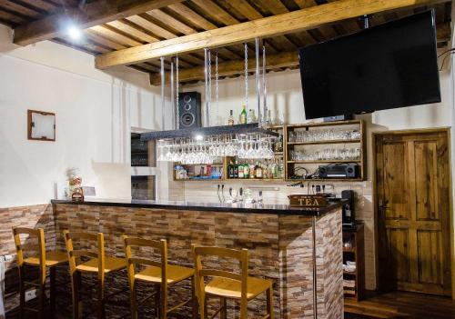 a bar with chairs and a flat screen tv at Vila Rhea in Važec