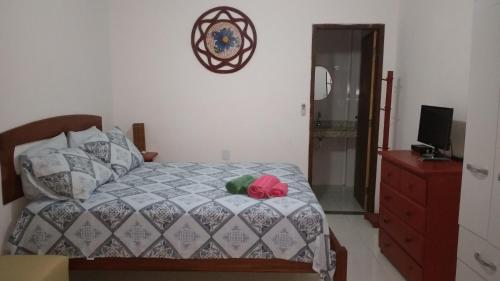 a bedroom with a bed and a dresser and a mirror at Pousada Recanto do Japa in Nilo Peçanha