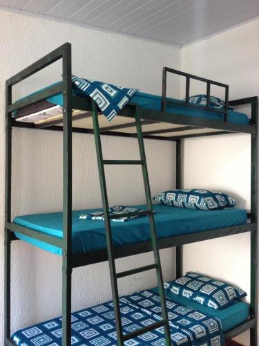 two bunk beds in a room with blue sheets at Casamatta Hostel in Pirenópolis