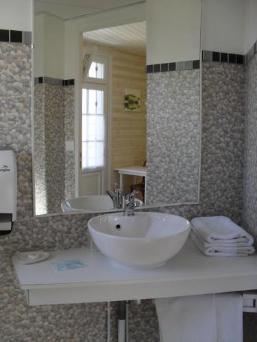 une salle de bain avec un lavabo et un grand miroir dans l'établissement Hotel de l'Atlantique, à La Tranche-sur-Mer