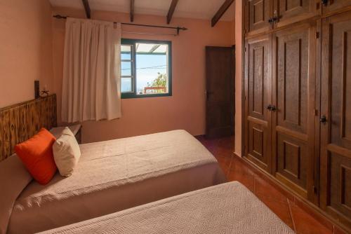 IsoraにあるCasa Abuelo Buenaventuraのベッドルーム1室(ベッド2台、窓付)