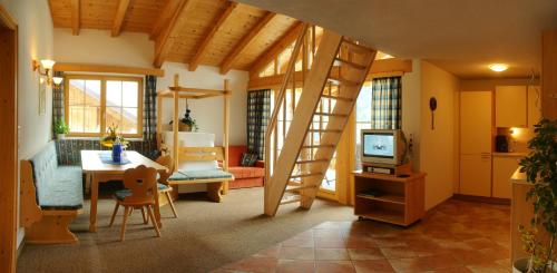 a living room with a ladder and a room with a table at Landhaus Raich in Jerzens