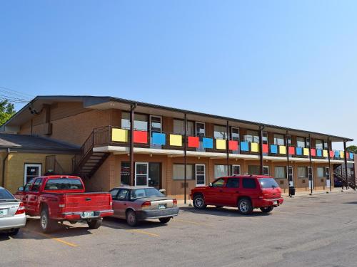 a building with cars parked in a parking lot at Westgate Inn in Portage La Prairie