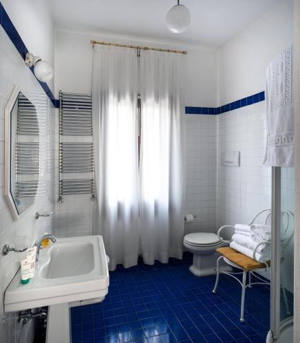 a blue and white bathroom with a sink and a toilet at Casa Lunia Guesthouse in Mestre