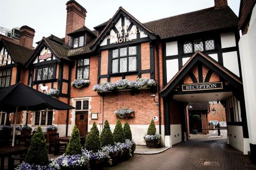 um hotel com flores em frente a um edifício em The White Hart Hotel em Kingston upon Thames