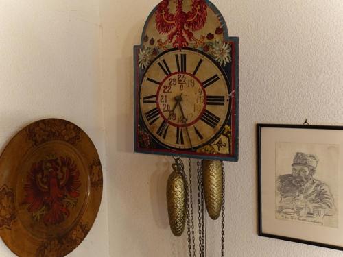 a clock hanging on a wall next to a picture at Ferienhaus Posthüttl in Virgen