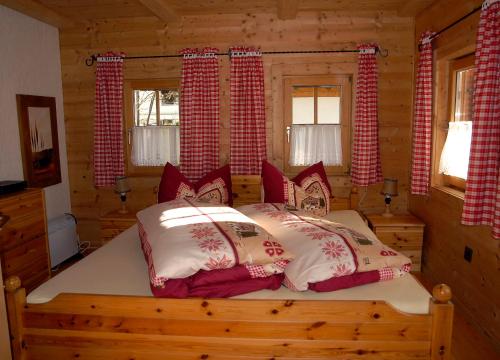 sypialnia z łóżkiem w chacie z bali w obiekcie Ferienhaus Posthüttl w mieście Virgen