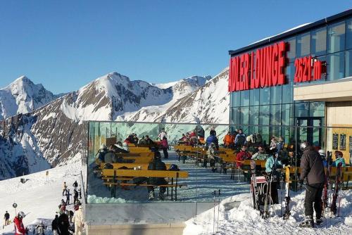 a group of people sitting outside of a building in the snow at Ferienhaus Posthüttl in Virgen