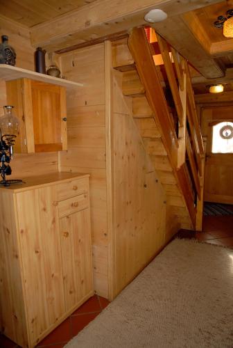 a log cabin kitchen with a staircase in the attic at Ferienhaus Posthüttl in Virgen