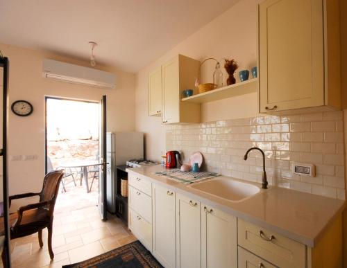 a kitchen with white cabinets and a sink at Peace and quiet in Kammon