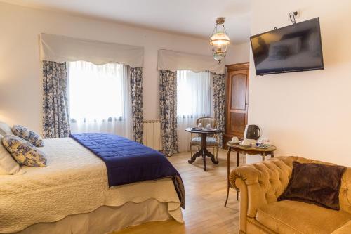 a bedroom with a bed and a couch at Virreinato Hotel Boutique in Cordoba