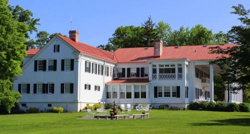 una gran casa blanca con techo rojo en Historic Rosemont Manor, en Berryville