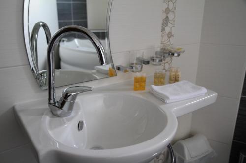 a bathroom sink with a mirror and a sink at Hotel Trebjesa in Nikšić