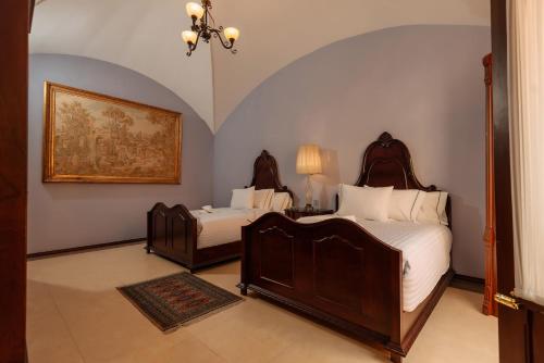 ein Schlafzimmer mit 2 Betten und einem Wandgemälde in der Unterkunft Hotel Marqués del Ángel in Puebla
