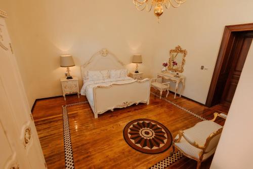 a bedroom with a bed and a chair and a mirror at Hotel Marqués del Ángel in Puebla