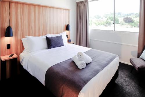 a hotel room with a bed with two towels on it at No. 9 Hotel in Auckland
